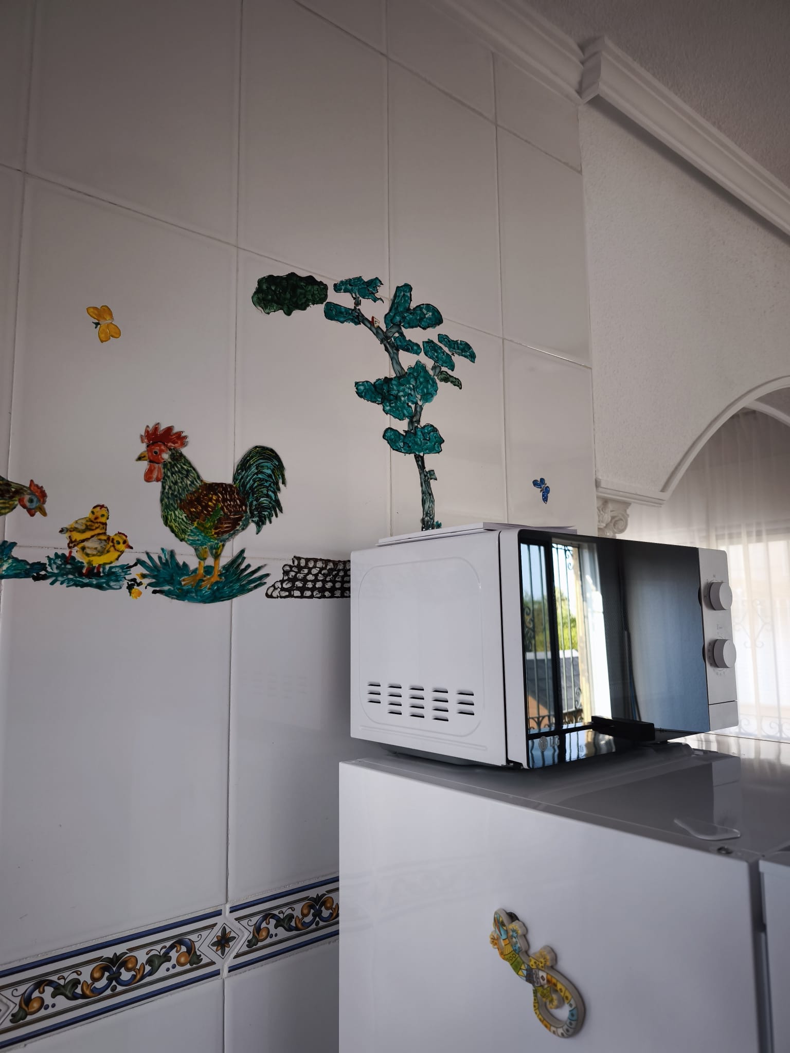 Kitchen with microwave and decorative tiles
