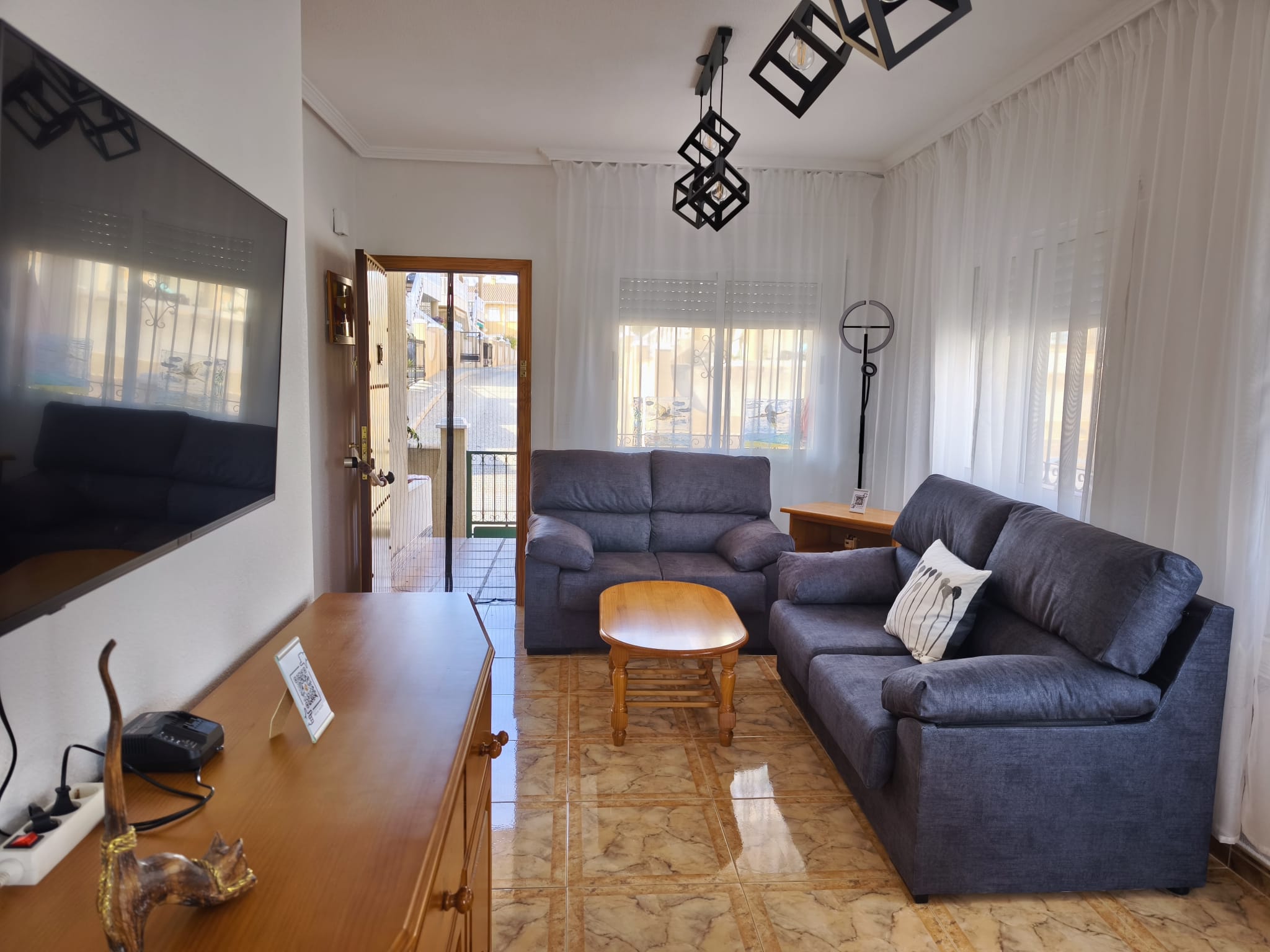 Spacious living room with large TV and comfortable sofas